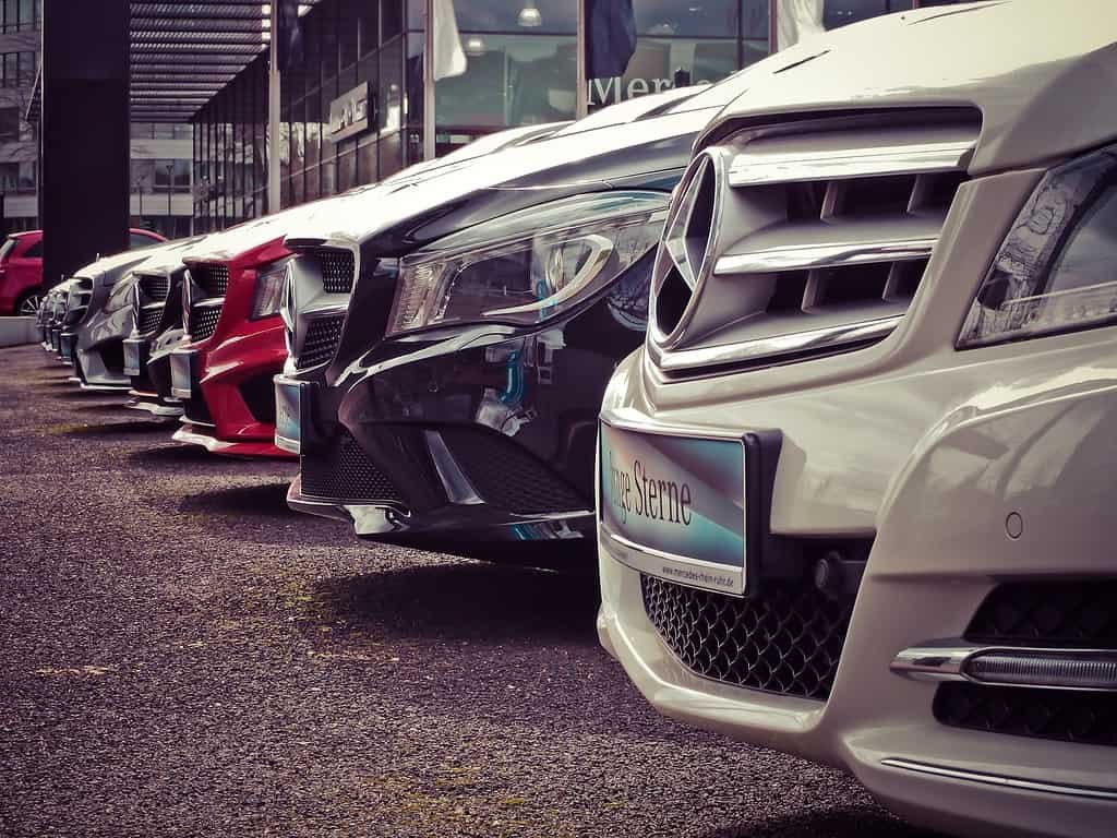 A row of mercedes benz cars parked in front of a building.