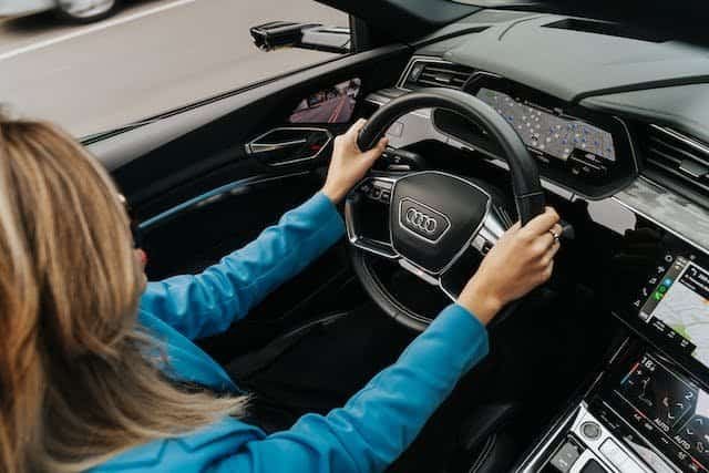 A woman driving an audi car.